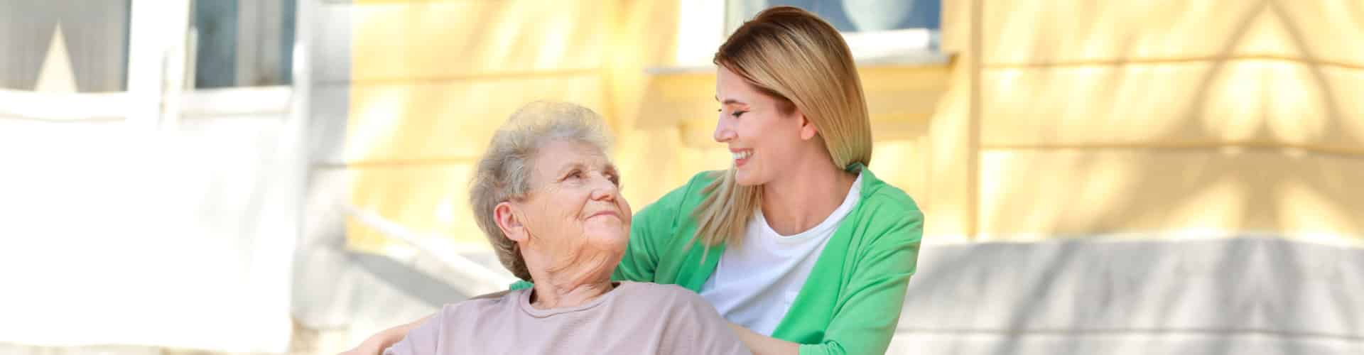 caregiver and senior woman looking at each other outdoor